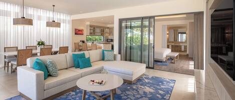 A modern living room with a sofa, coffee table, and dining area.