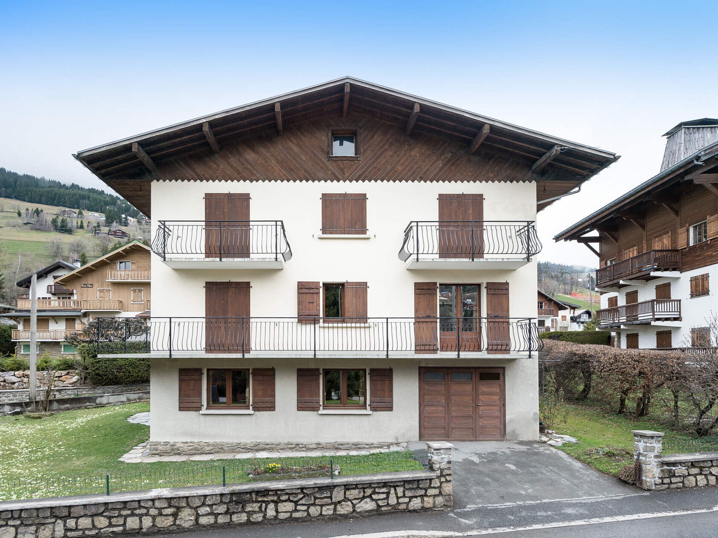 A two-story building with wooden balconies and a stone foundation.