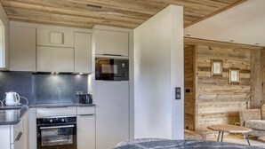 A modern kitchen with a built-in oven, a microwave, and a kettle on the countertop. - Charming 1-bedroom near Megève slopes (Megève)