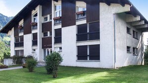 Ein mehrstöckiges Gebäude mit flachem Dach und einem Balkon im zweiten Stock.