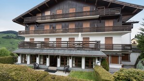 A multi-story wooden chalet with balconies and a covered entrance area.