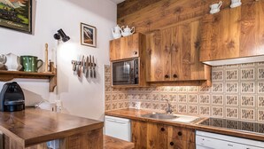 A kitchen with wooden cabinets, a microwave, a Bosch dishwasher, and a coffee maker.