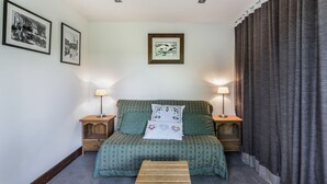 Una camera da letto con un letto, due comodini, una panca di legno e tre quadri appesi al muro.