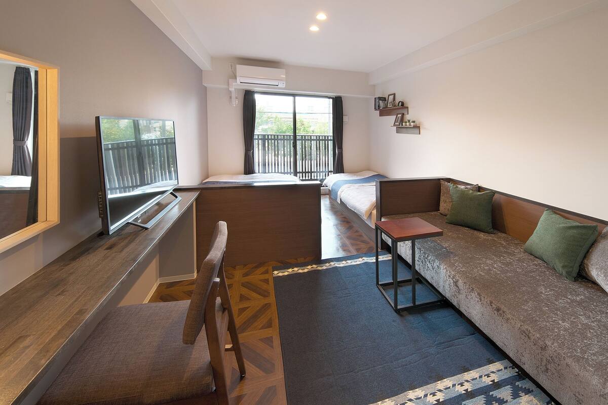 A modern room with a sofa, a chair, a small table, and a window with a view.