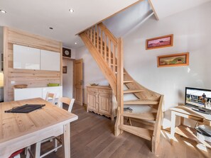 Une cuisine moderne avec des meubles en bois, une table à manger et un escalier.