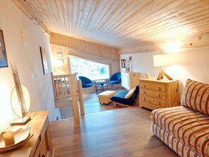 Ein Holzinterieur mit einer Couch, einem Schminktisch, einem Sessel und einer Lampe.