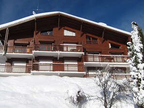 Ein mehrstöckiges Holzgebäude mit Balkonen, umgeben von Schnee.