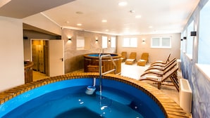 Uma área de spa com hidromassagem, espreguiçadeiras e piscina.
