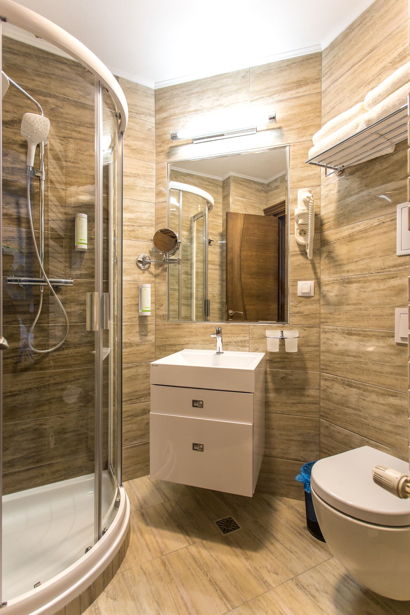 A modern bathroom with a glass shower enclosure, a vanity with a mirror, and a toilet.