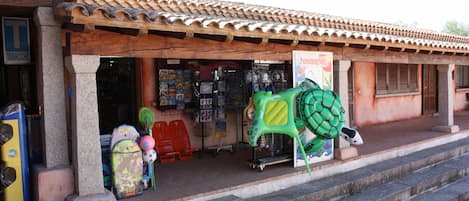 A storefront with a tiled roof, a signboard, and various items displayed outside.