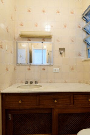 A bathroom with a sink, mirror, and wooden cabinet. - Omar do Rio - SL906 (Rio de Janeiro)