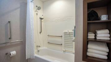 Une salle de bain moderne équipée d’une baignoire, d’une douche et d’un porte-serviettes.