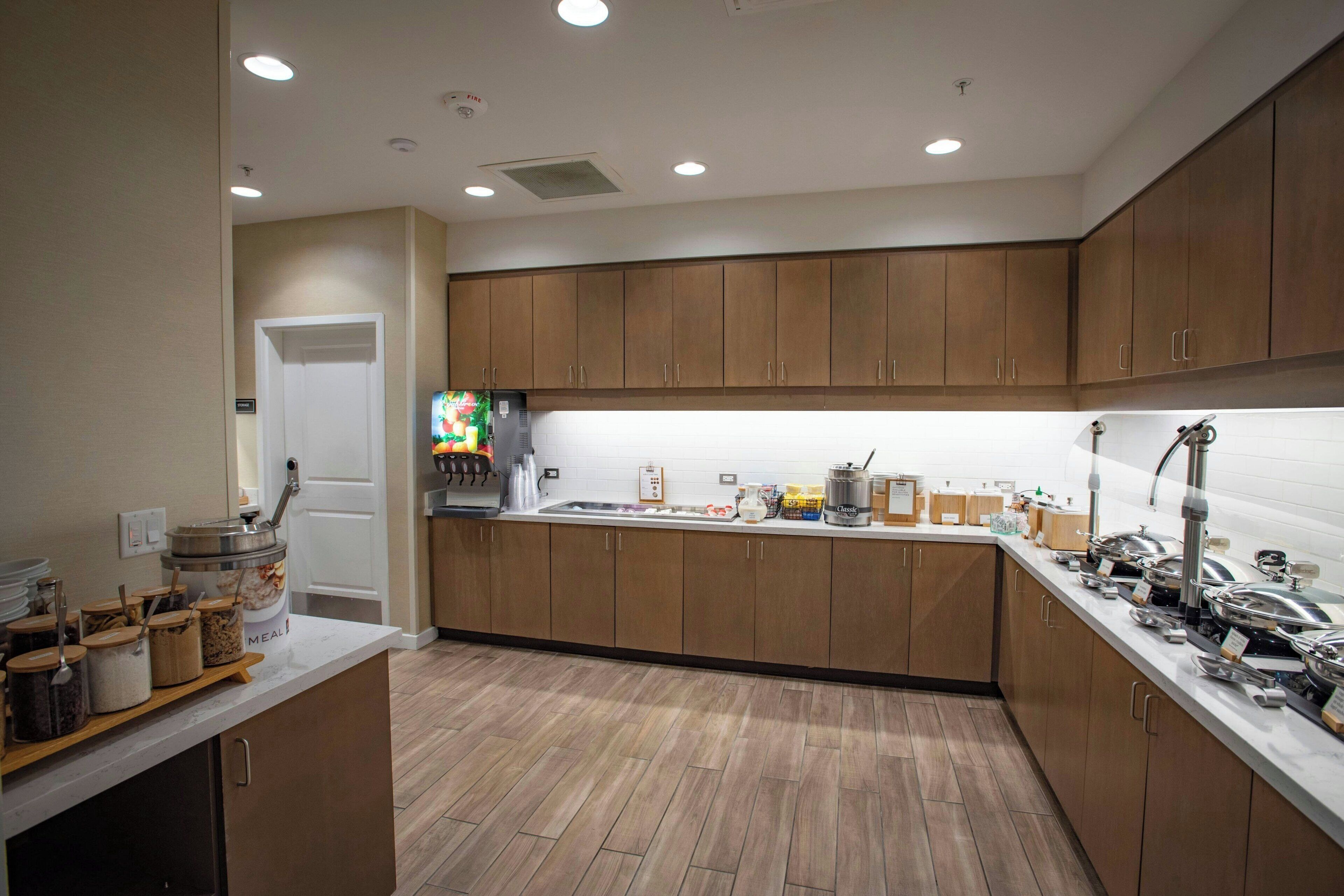 A modern kitchen with wooden cabinets, a central island, and various appliances.