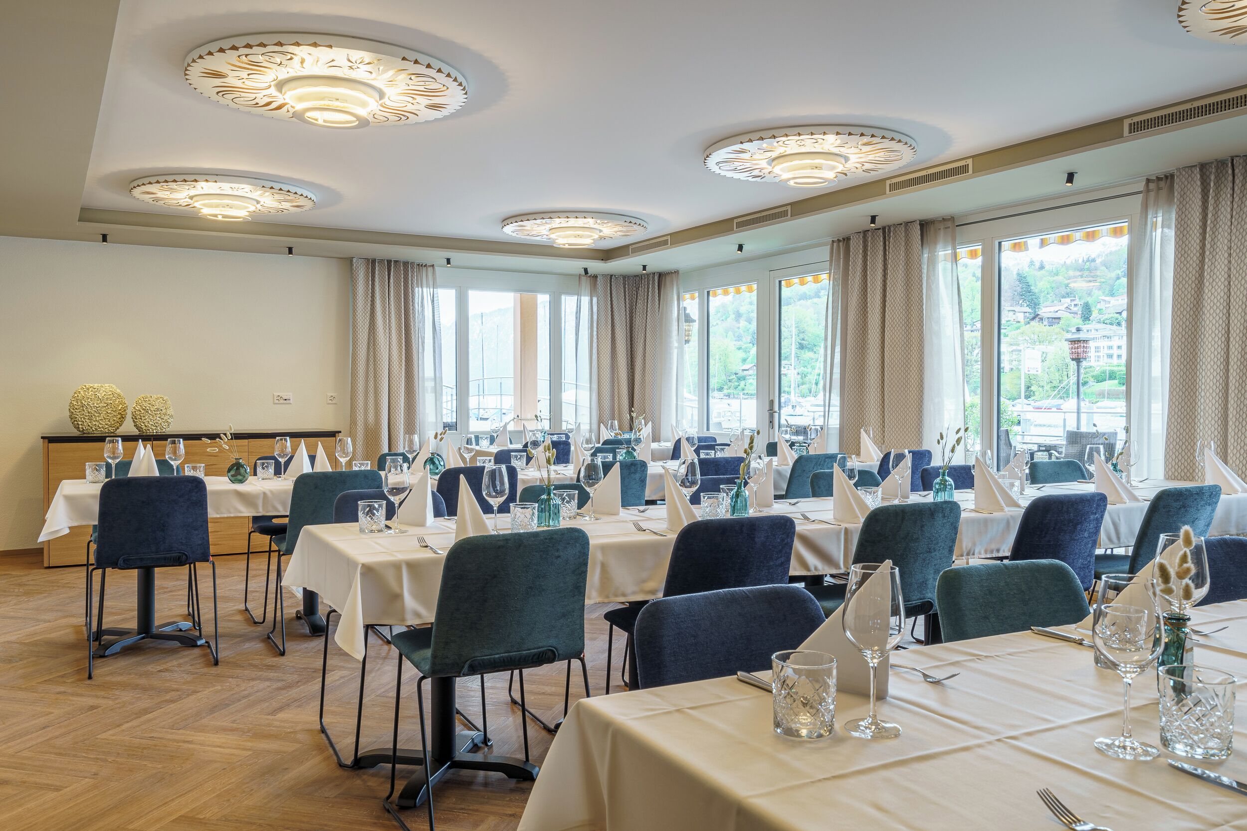 Ein Konferenzraum mit mehreren Tischen, Stühlen und einem Büfettbereich.