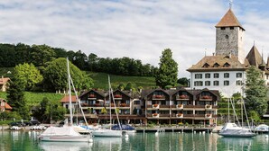 Un hôtel situé au bord de l’eau, doté de nombreux balcons, d’une tour et de bateaux amarrés dans la marina.
