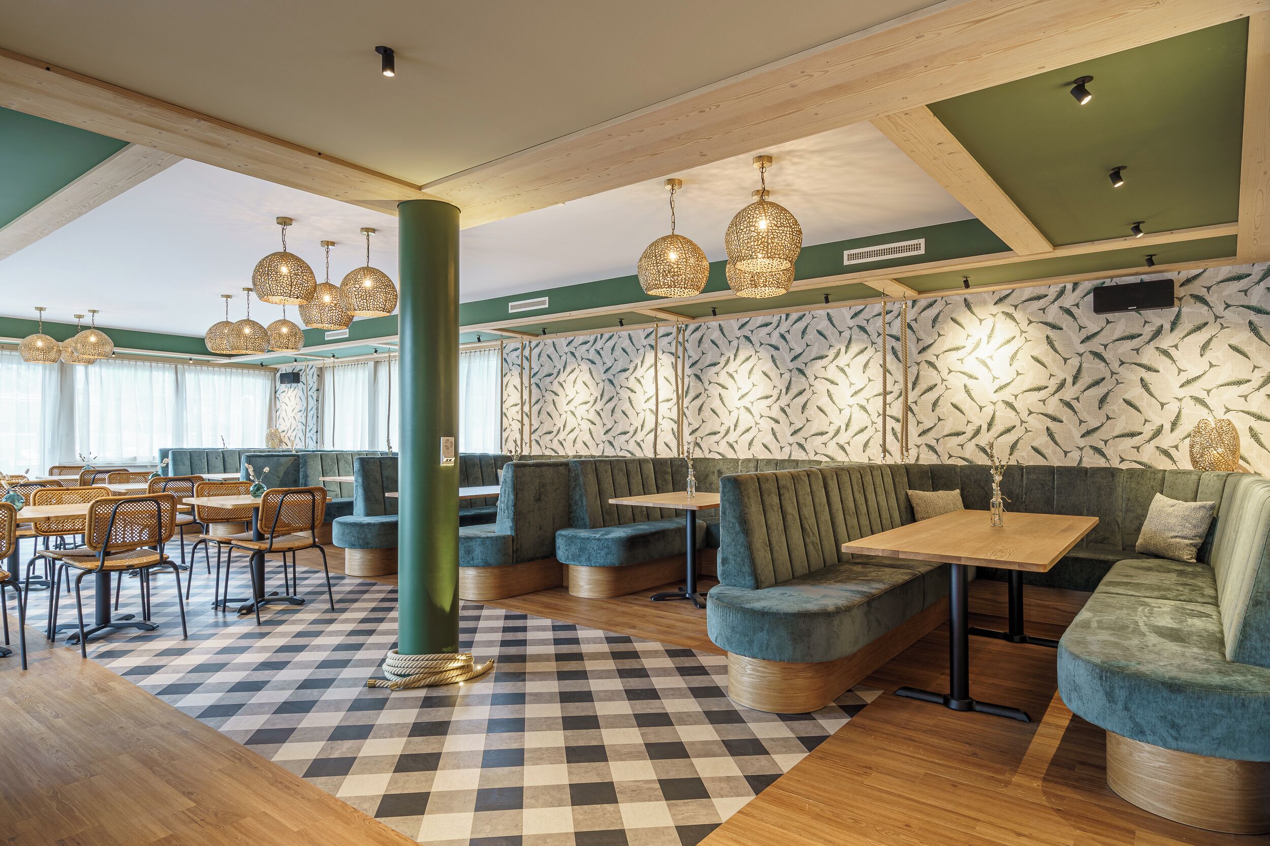 A restaurant with checkered flooring, green walls, and blue seating.