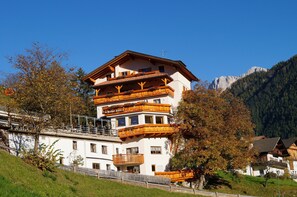 A multi-story hotel with balconies, a mountain backdrop, and a clear sky. - Gasthof Laurin (Tires)