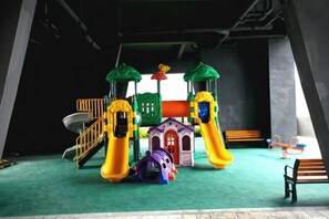 A children's play area with slides, a climbing structure, and a small building. - Muhai Resort Apartment (Huidong)