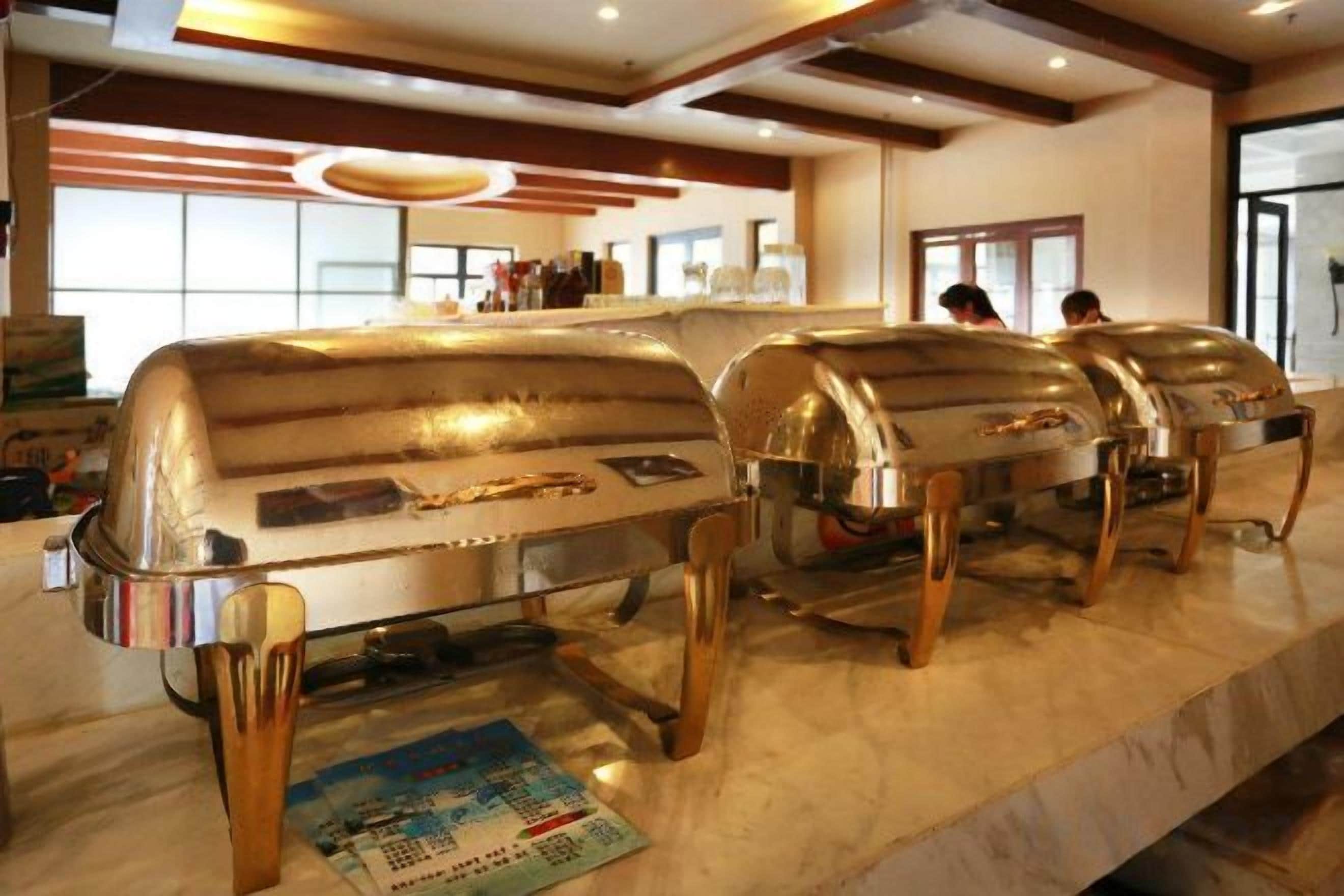 Un'attrezzatura per buffet con diverse ciotole da portata in acciaio inossidabile su un piano di lavoro in marmo.
