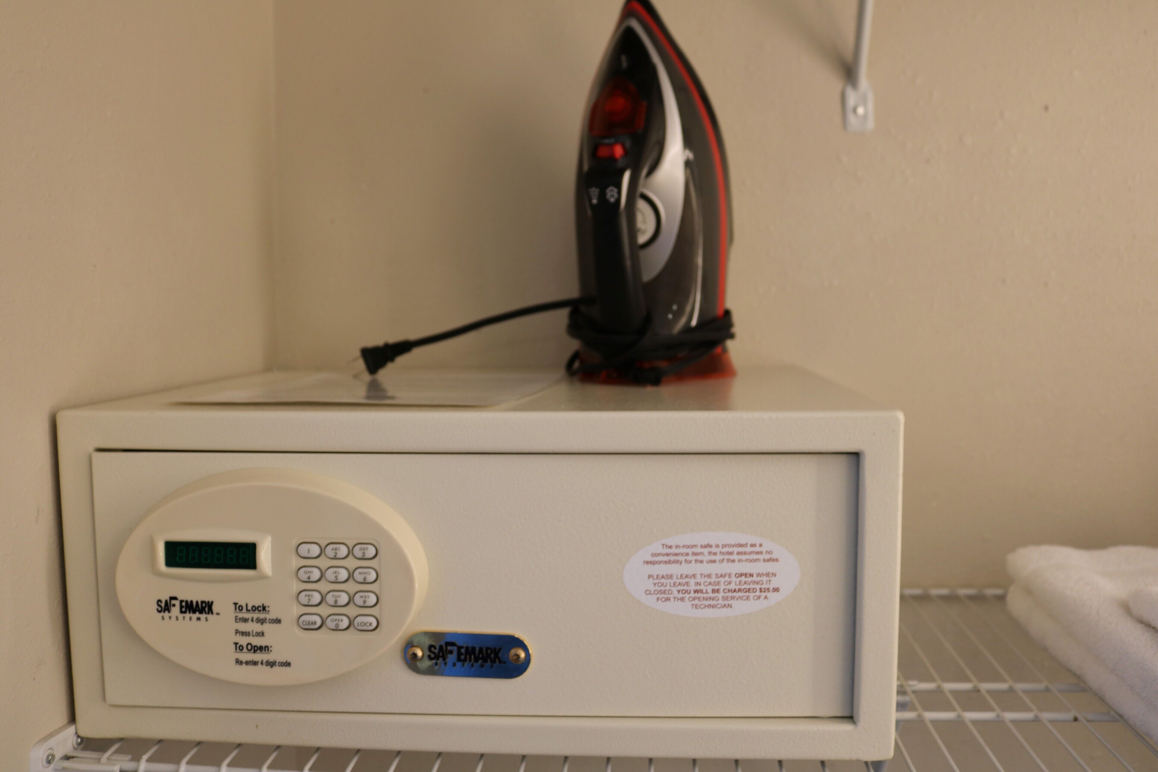 A control panel with a digital display and a keypad, a safety lock system, and a warning label.