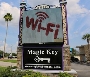 A hotel sign with a Wi-Fi symbol, a key symbol, and the name 'Magic Key'.