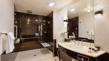Un baño moderno con un espejo grande, lavamanos dobles y una zona de ducha.