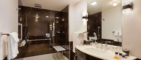 Un baño moderno con un espejo grande, lavamanos dobles y una zona de ducha.