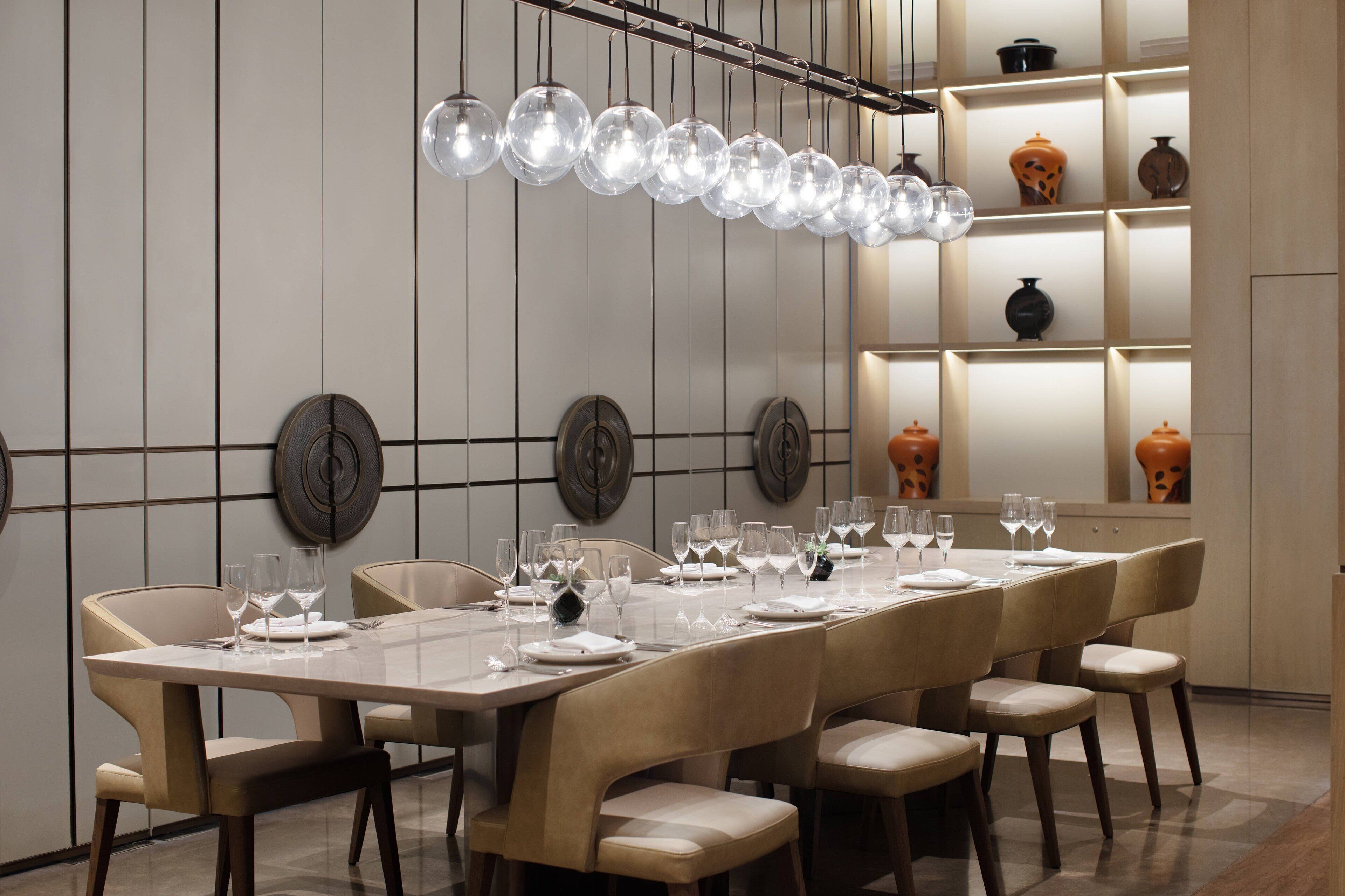A dining area with a long table set for multiple guests, surrounded by chairs.