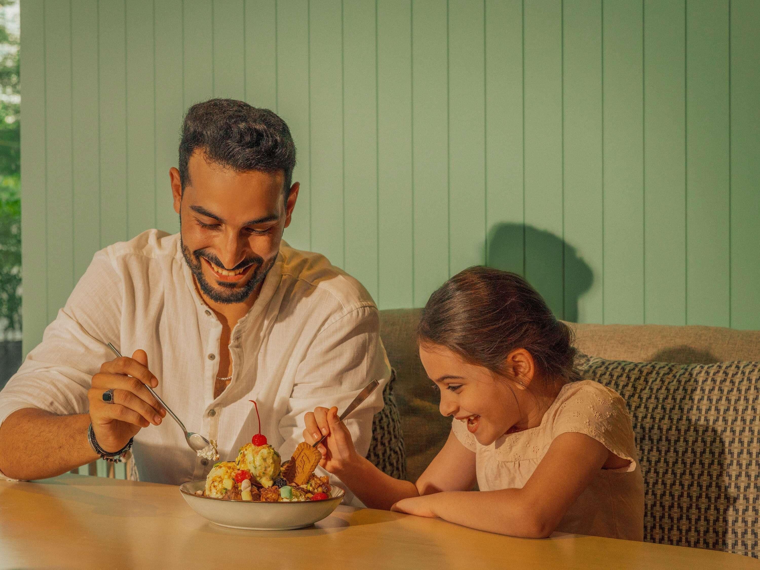 A dining table with a bowl of food and a person eating.