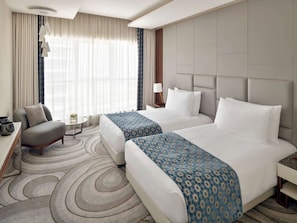 Relax in this stylish room with two single beds, a comfortable armchair, and a beautiful view.