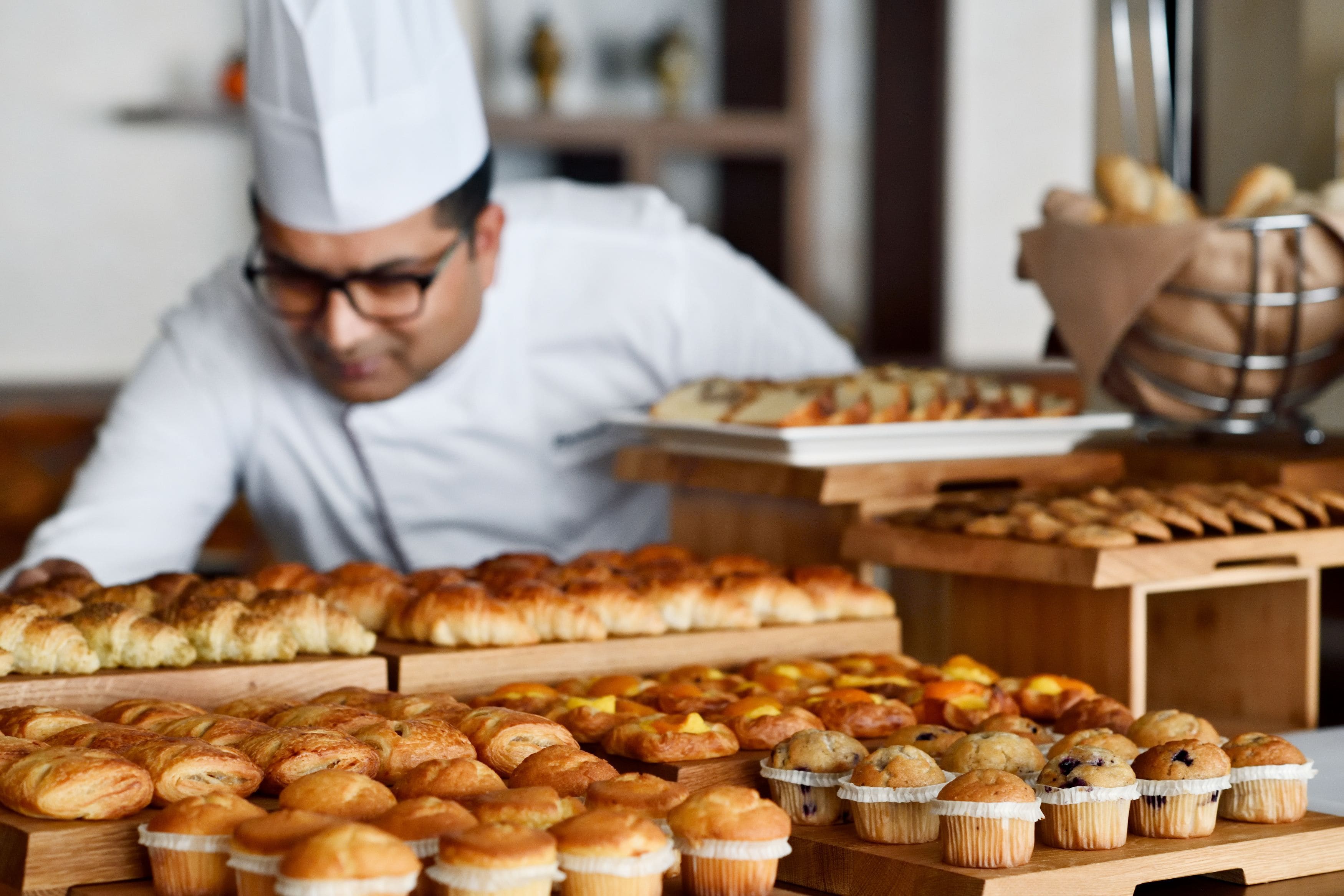 A bakery with various baked goods displayed on wooden stands.