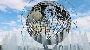 A large metallic globe structure surrounded by a water fountain display.