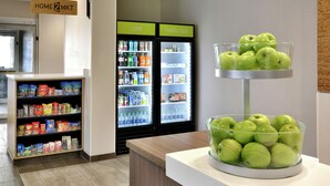A vending machine area with snacks and beverages, and a display of green apples. - Home2 Suites by Hilton Duncan (Duncan)