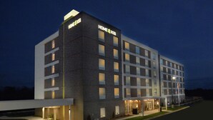 A multi-story hotel with a modern design, featuring a prominent entrance with a glass facade and a well-lit exterior. - Home2 Suites by Hilton Duncan (Duncan)