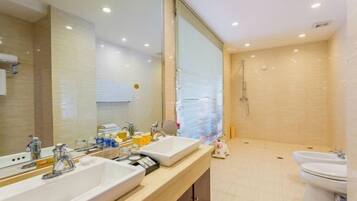 Un baño moderno con dos lavabos, un espejo grande, ducha e inodoro.