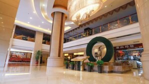 A spacious, multi-level atrium with a large circular decorative element, polished floors, and multiple levels of balconies. - Tianlong Hotel (Baotou)