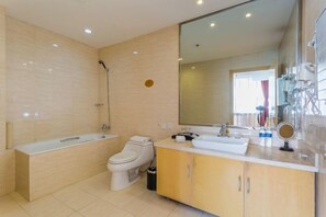 A modern bathroom with a bathtub, toilet, vanity, and large mirror. - Tianlong Hotel (Baotou)
