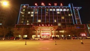Een hotel met een opvallende ingang en verlichte borden.