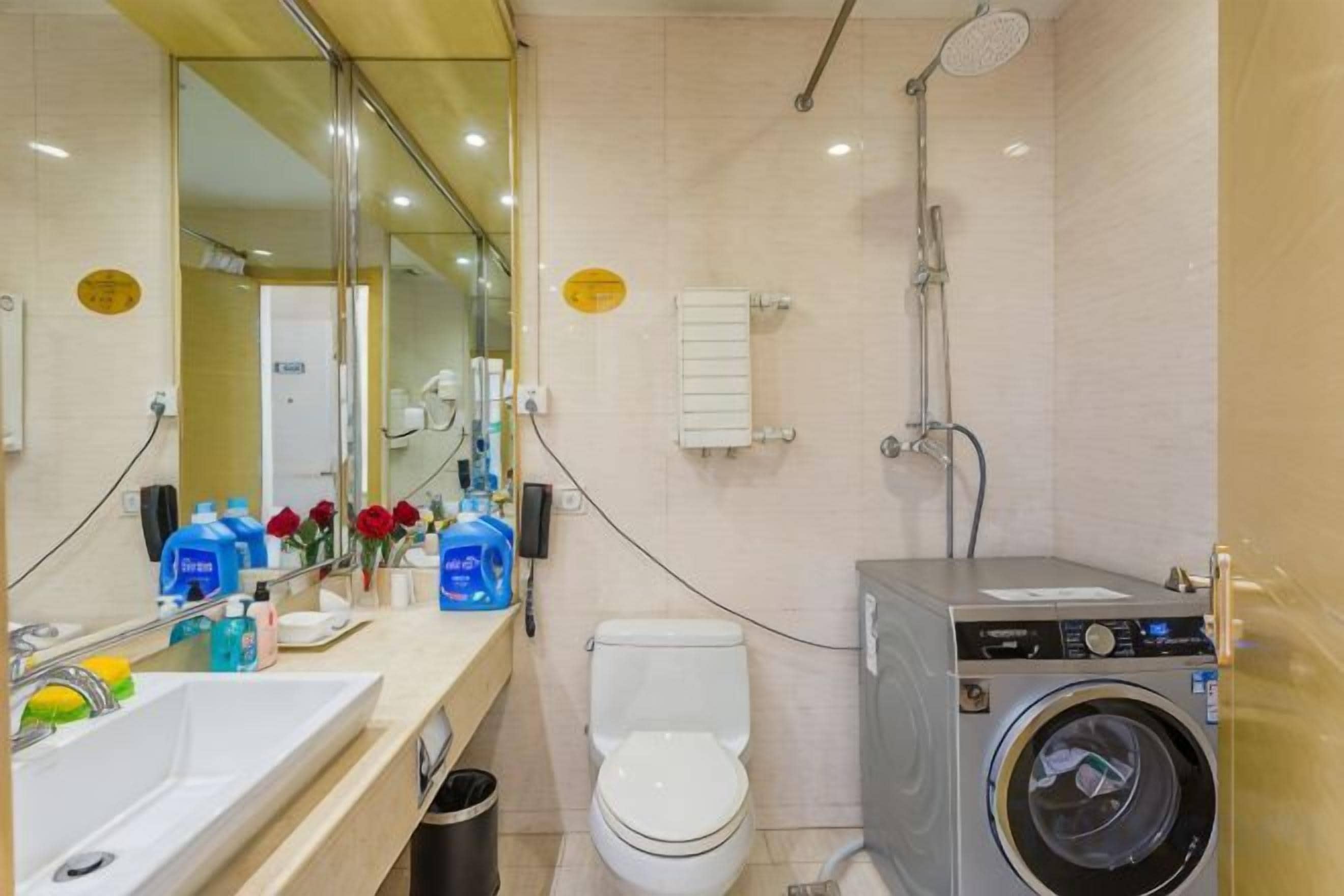 A bathroom with a sink, toilet, and washing machine.