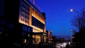A hotel with a modern facade, large windows, and a well-lit entrance. - Tianlong Hotel (Baotou)