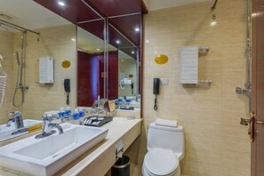 A modern bathroom with two sinks, a toilet, a shower, and a large mirror. - Tianlong Hotel (Baotou)