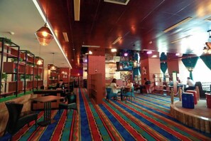 A cozy indoor space with seating areas, a patterned carpet, and a variety of lighting fixtures. - Tianlong Hotel (Baotou)