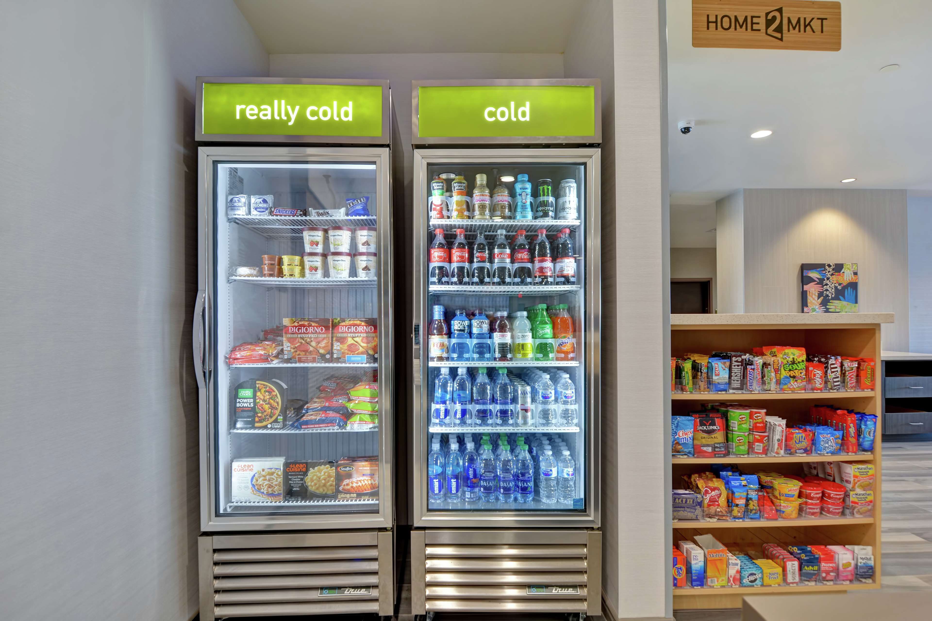 Deux distributeurs de boissons réfrigérés, portant les mentions « très froid » et « froid », et contenant une variété de boissons et d’en-cas.
