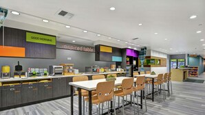 A modern cafe with a counter, seating area, and a sign that reads "GOOD MORNING". - Home2 Suites by Hilton Springdale (Springdale)