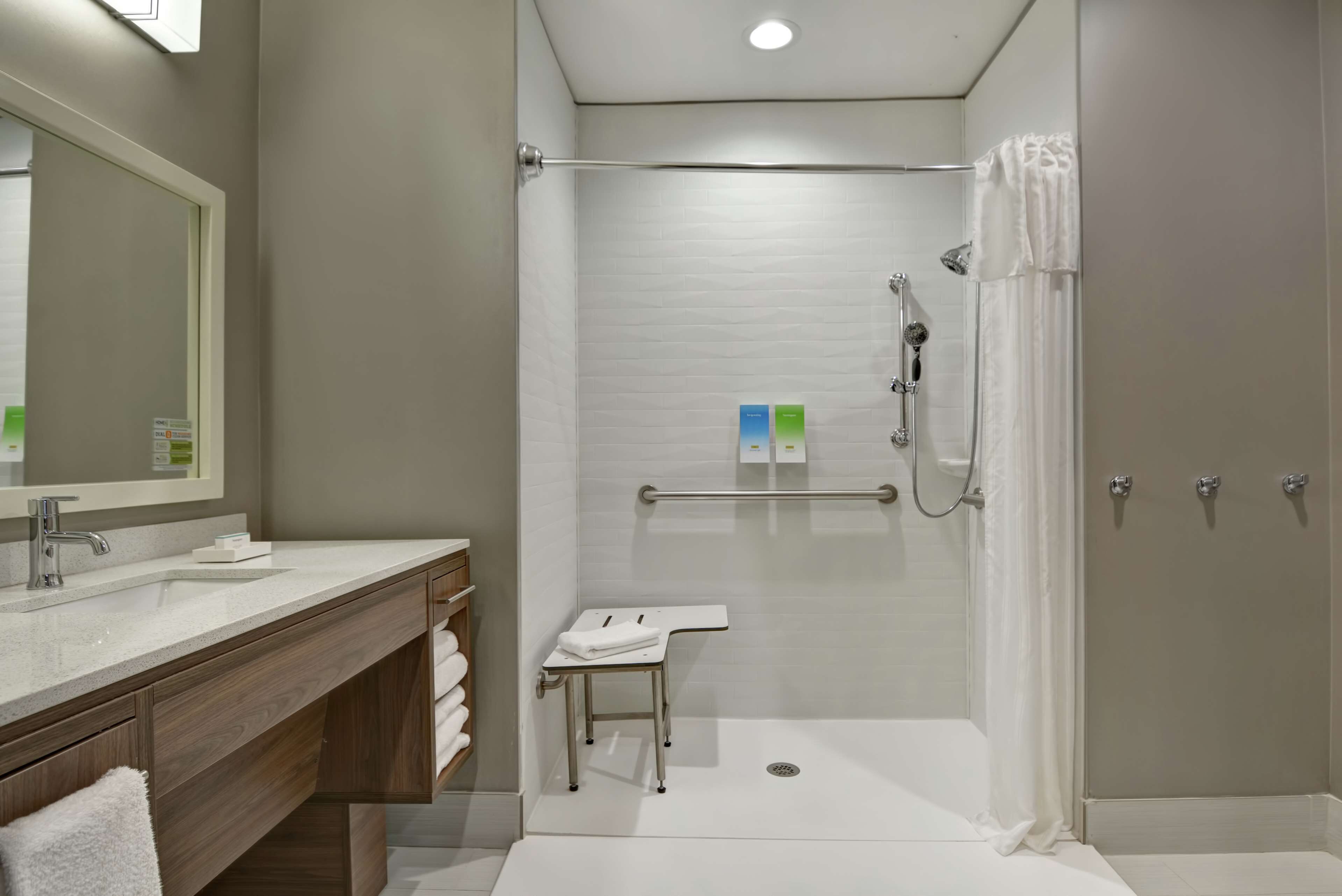 Une salle de bain moderne avec une douche à l’italienne, un meuble-lavabo avec un miroir et des toilettes.