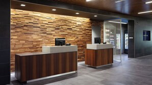 A modern reception area with wooden panel walls and two reception desks. - Courtyard by Marriott Winter Haven (Winter Haven)