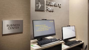Een businesscenter met een computerinrichting, een bord met de naam van het businesscenter en een bord voor de boarding pass.