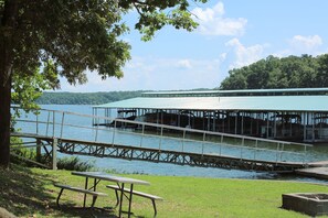 A lakeside dock with picnic tables and a covered boat launch area. - Lynnhurst Family Resort (Murray)