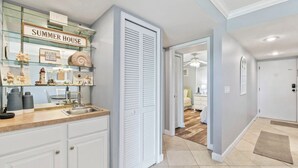 A modern kitchen with a glass display case, a sink, and a countertop. - Beachfront Community Condo – Dune View, Easy Beach Access, Resort Amenities (St. Augustine)