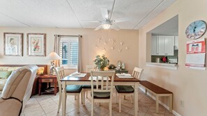 A dining area with a table and chairs, a ceiling fan, and starfish decorations on the wall.